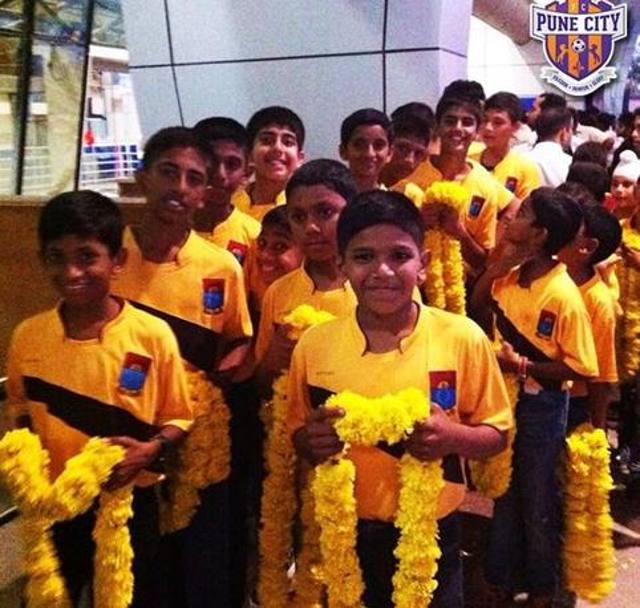 Decine di giovani indiani in fila con le tipiche  collane di fiori